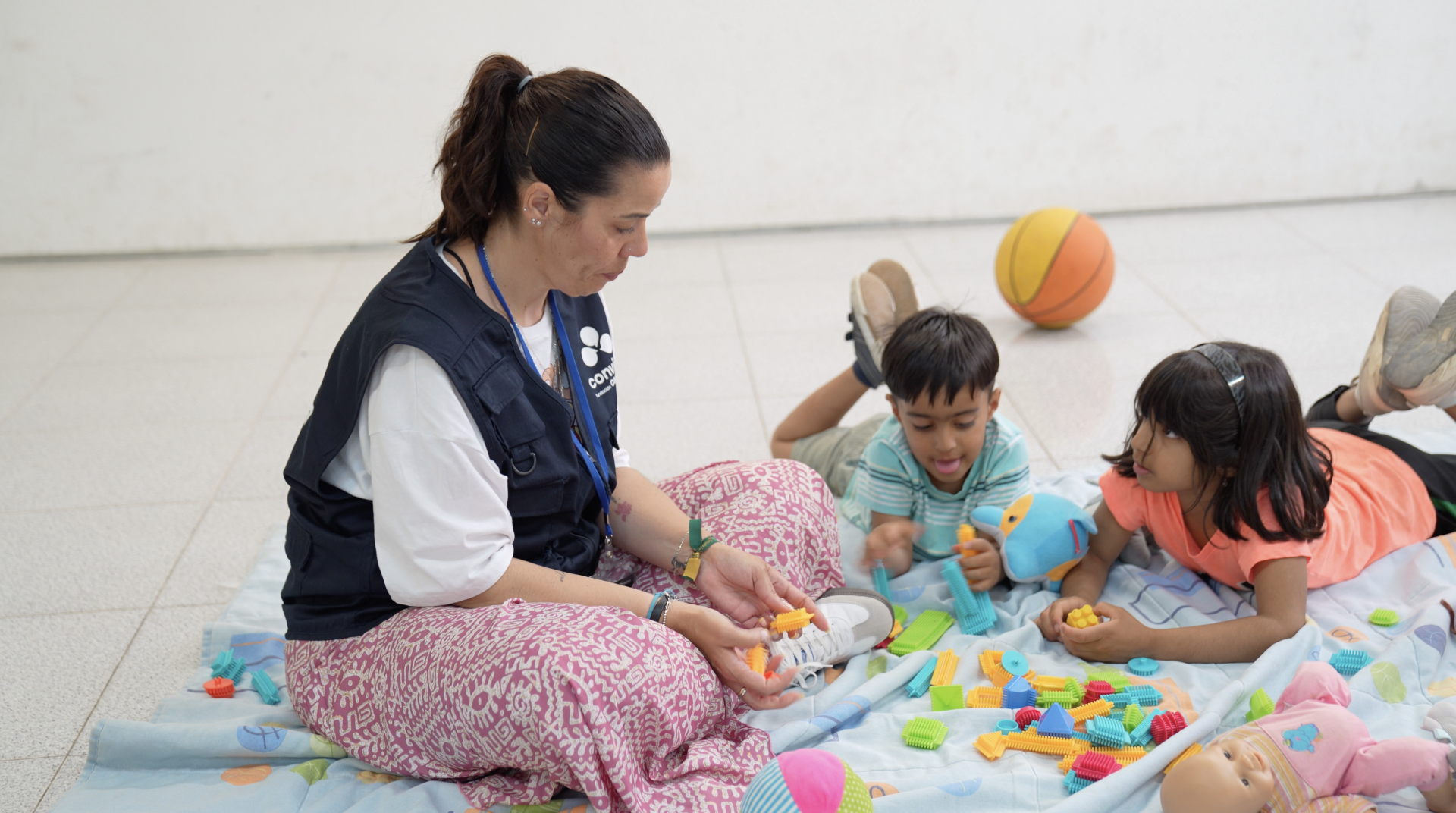 voluntaria niño y niña inmigrantes en taller de convivencia