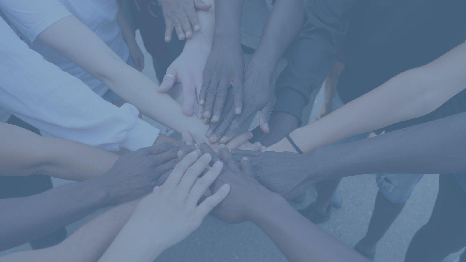 fondo azul con manos de personas diferentes unidas
