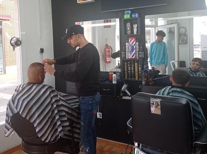 joven migrante emprendedor en su barbería