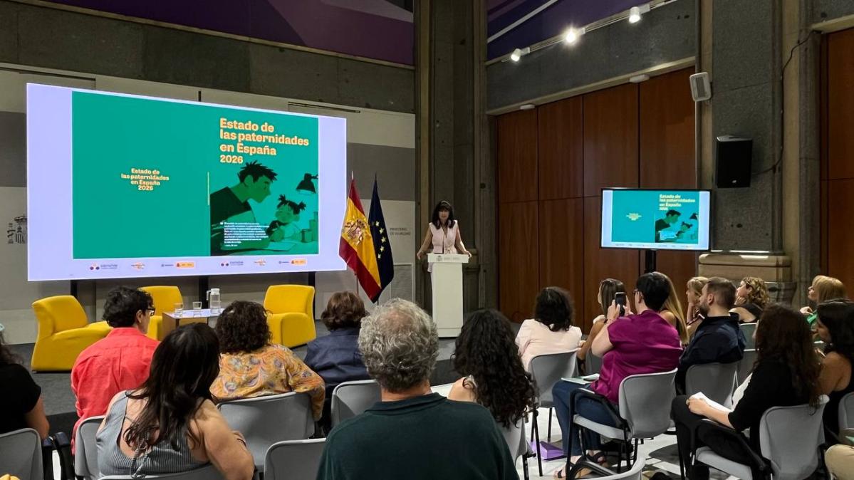 Ministra Ana Redondo y público en evento sobre cuidados y paternidades