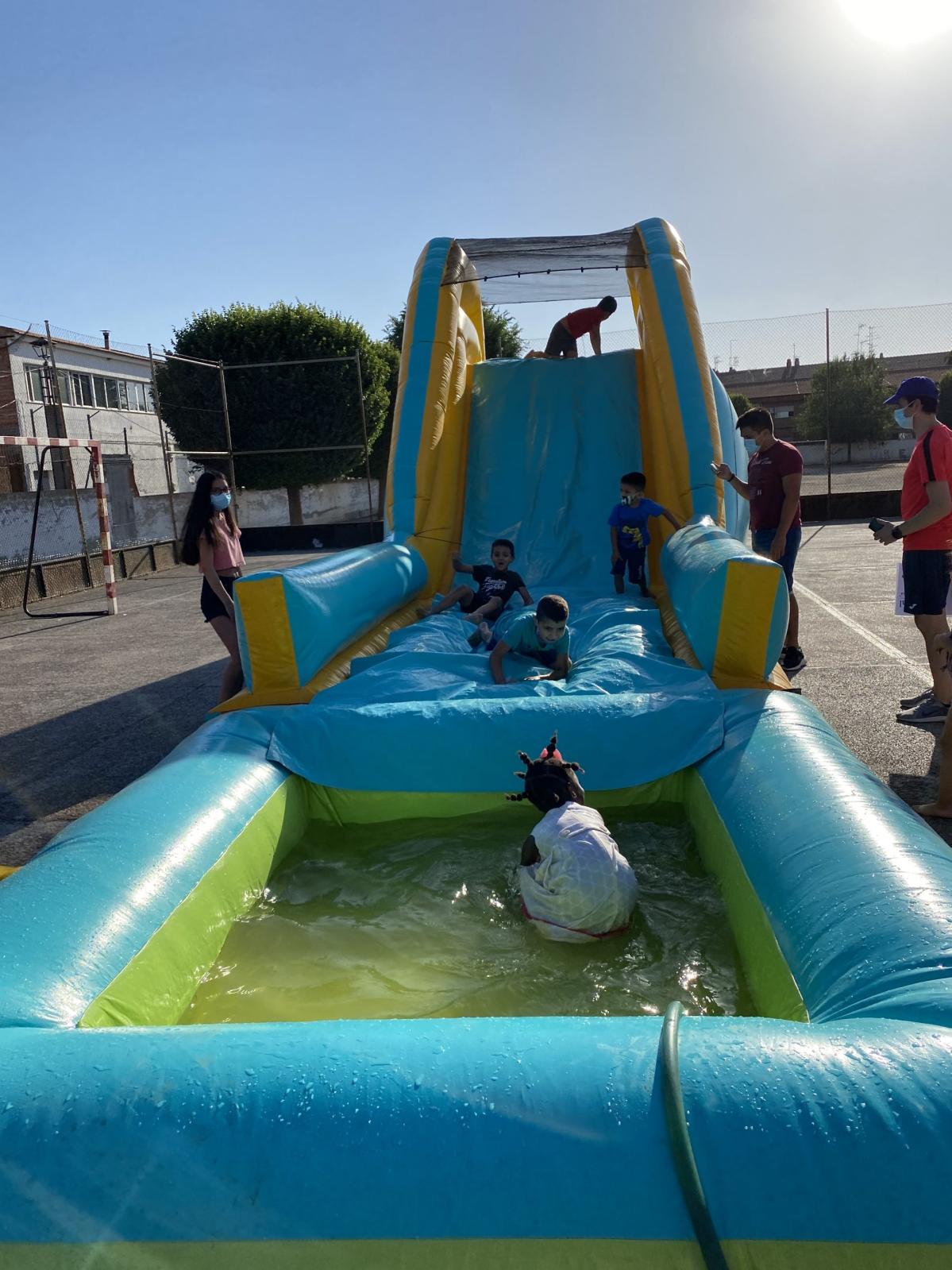 Niños y niñas refrescándose en el hinchable acuático